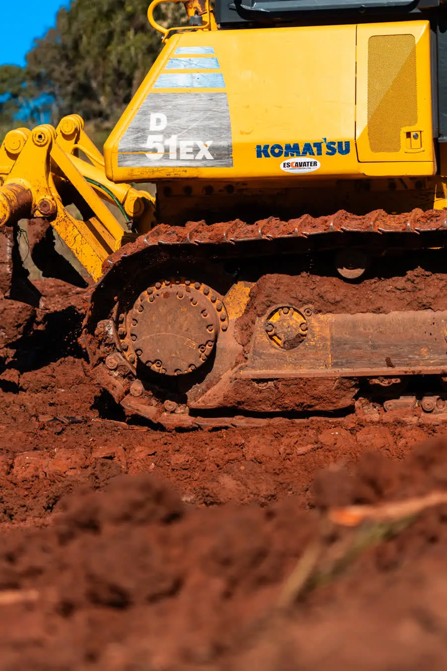 Trator de esteira Komatsu nivelando terra vermelha, Escavater